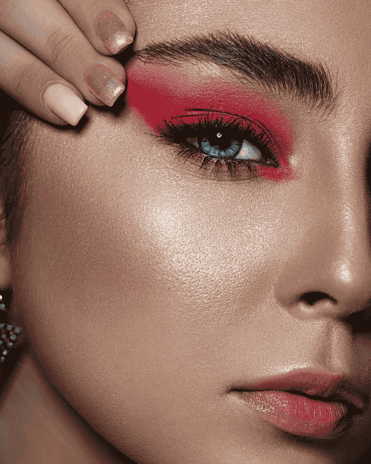 Close up editorial portrait with bold red eyeshadow and dramatic beauty styling